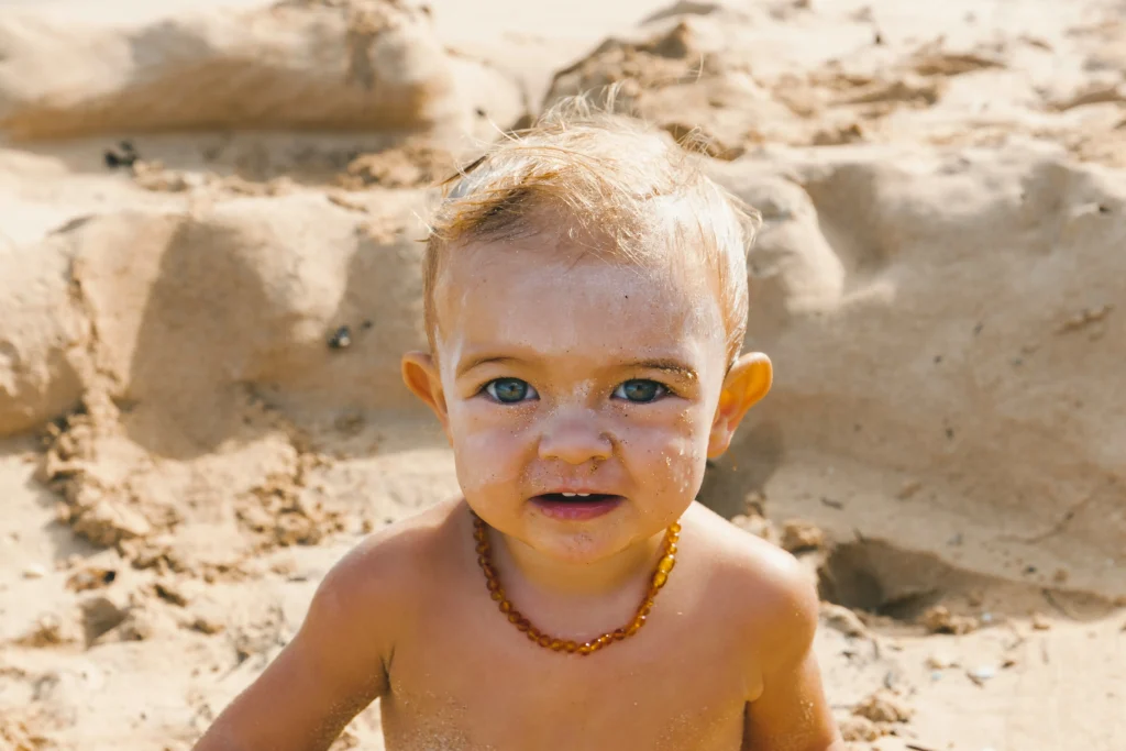 baby boy in the sand enjoying