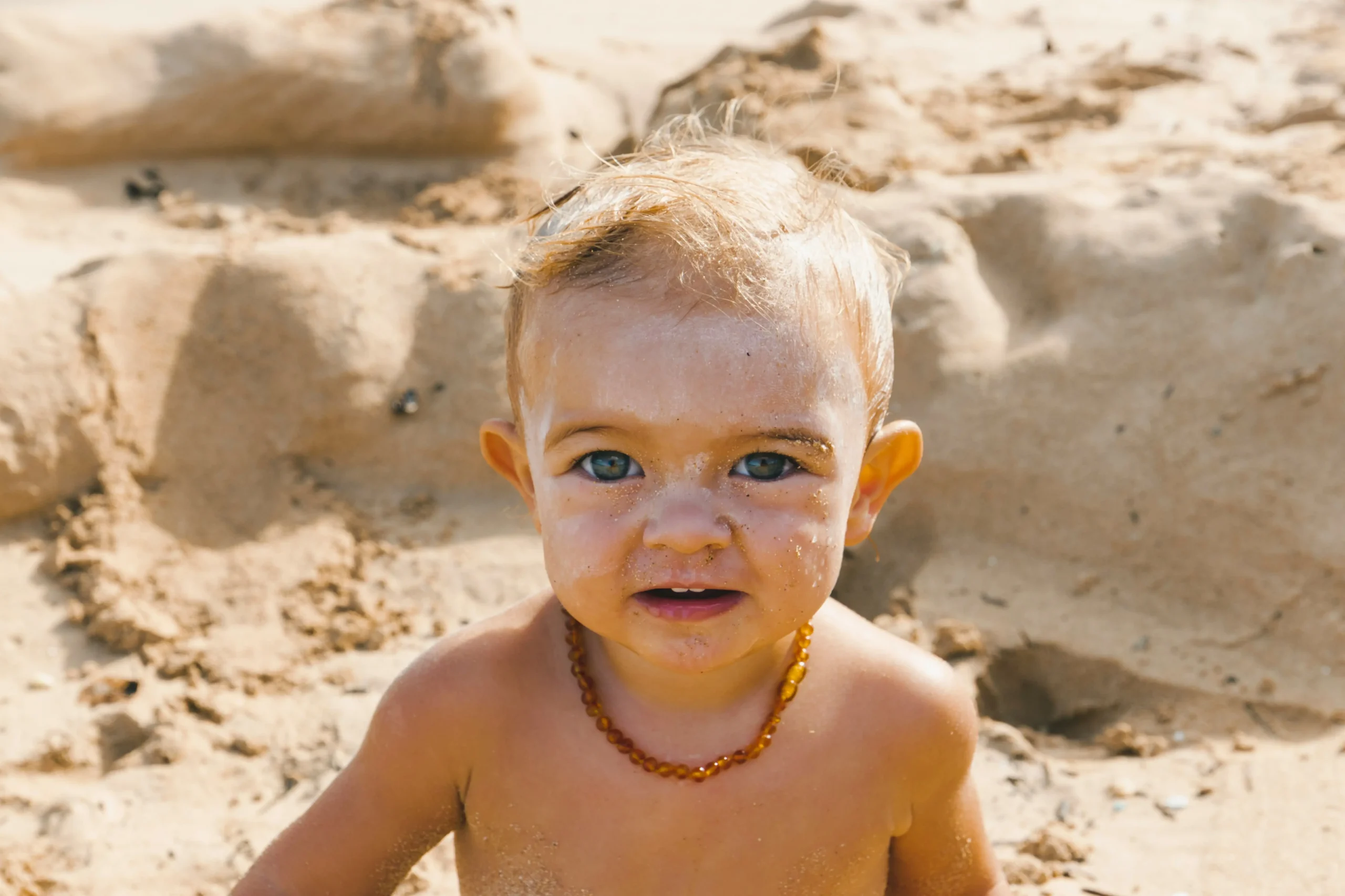 baby boy in the sand enjoying