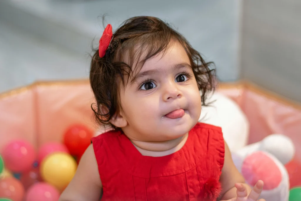 little beautiful girl sitting on ball pit