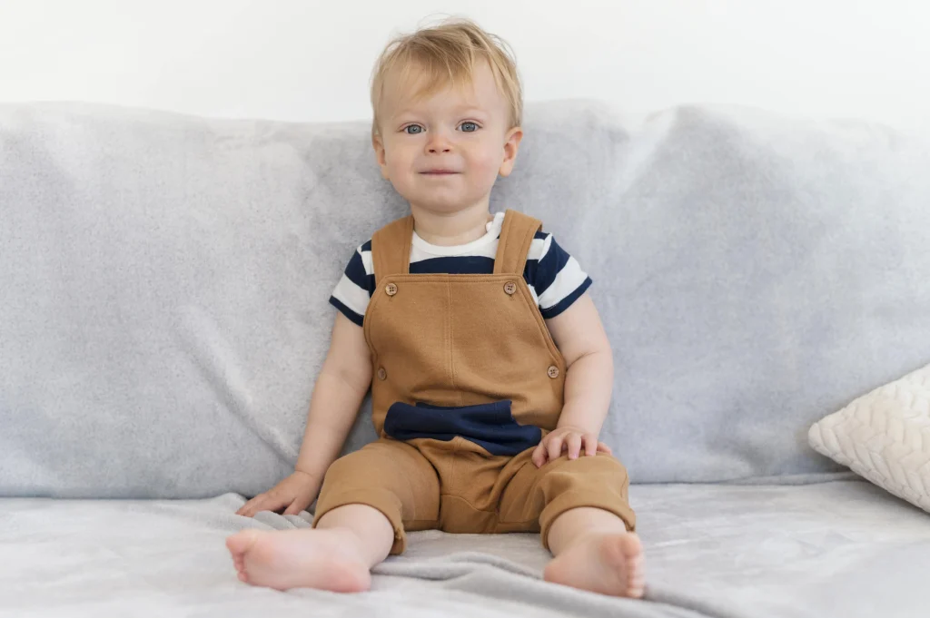 cute baby boy sitting on couch 