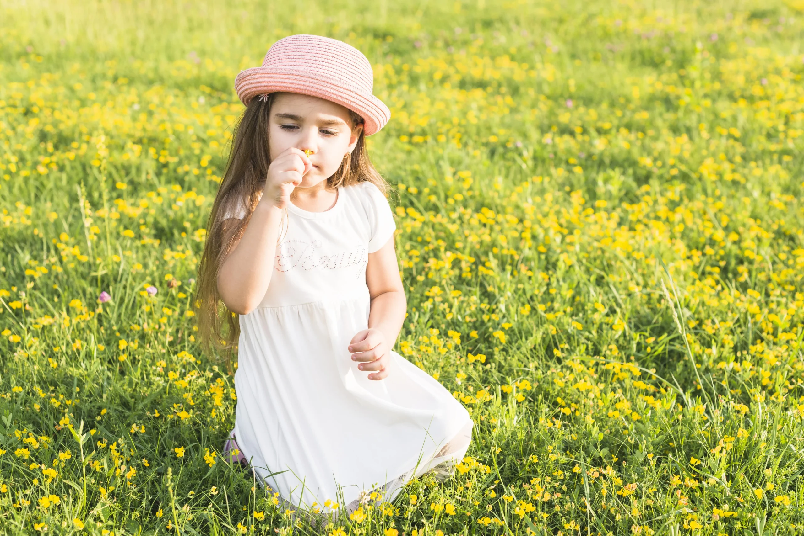 little girl smelling flower in spring